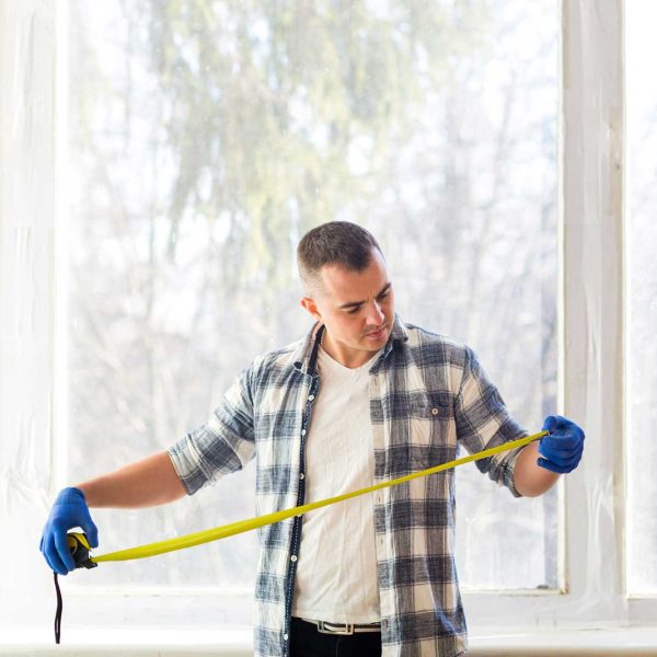 Homme mesurant la surface du bâtiment